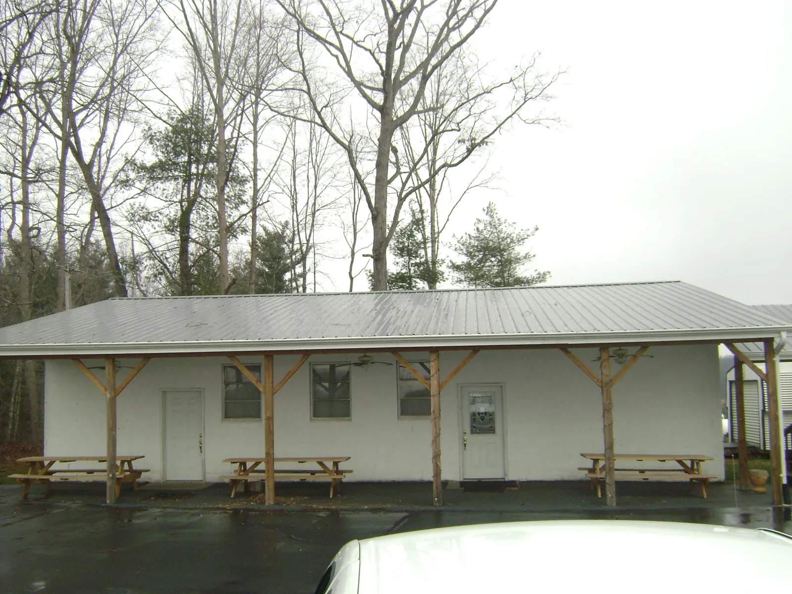 Gray metal roof over a block building with a timber post porch in Newfield